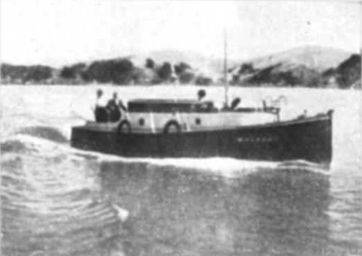 A sepia photo, taken in the early 1900s, of a 30 foot fishing boat, with two people on board and heading along the coast in the Bay of Islands